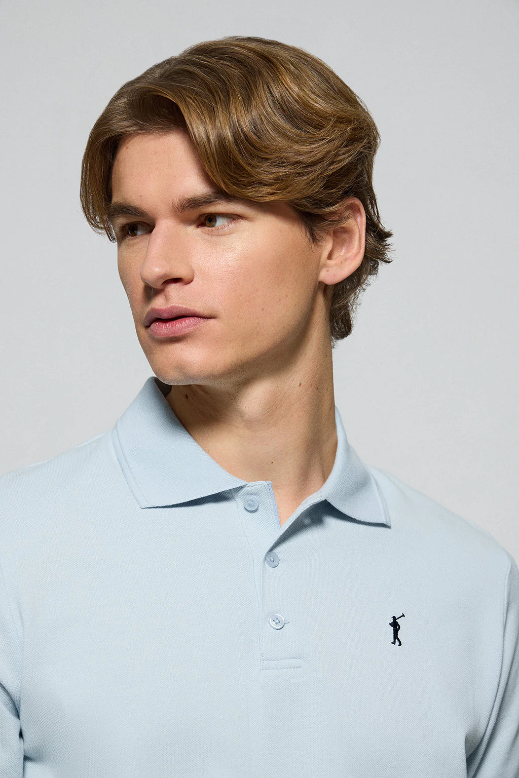 Light-blue polo shirt with three buttons and Rigby Go embroidered logo
