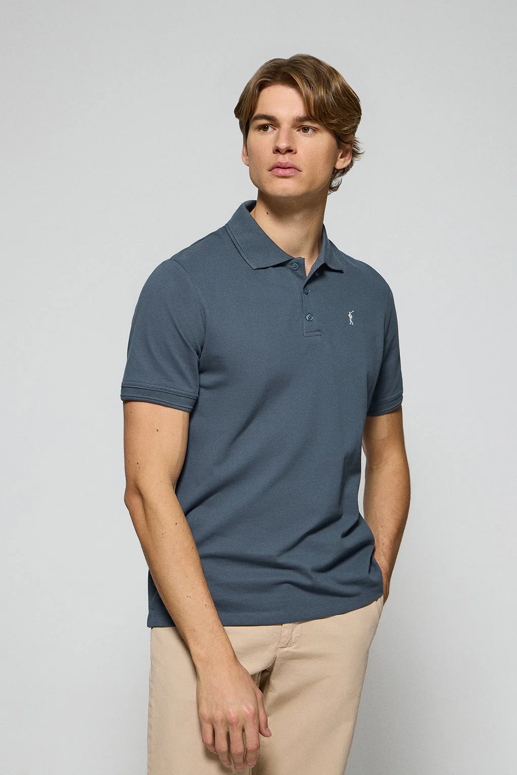 Denim-blue polo shirt with three buttons and Rigby Go embroidered logo