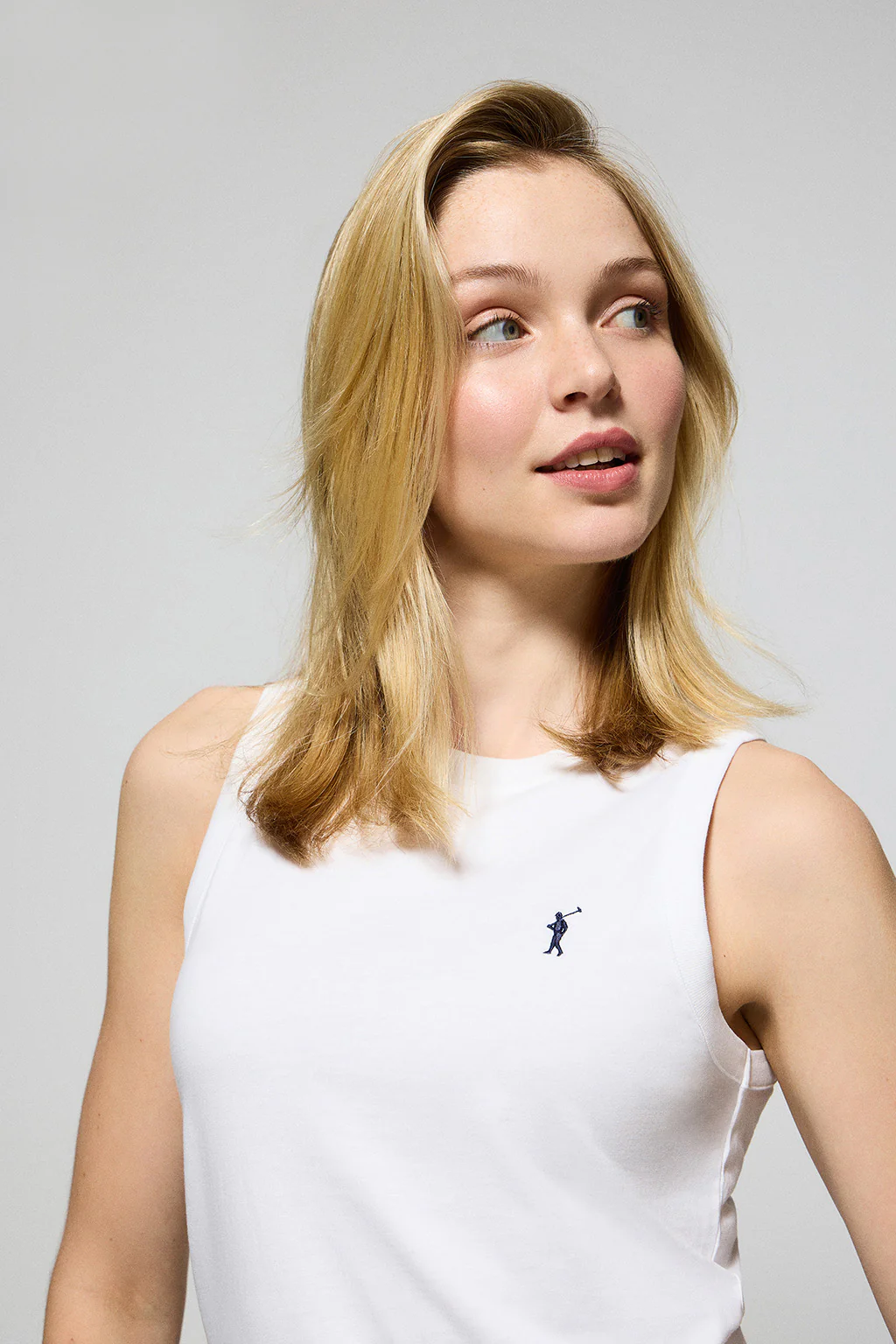 White sleeveless basic tee with round neck and Rigby Go embroidered logo - Image 3